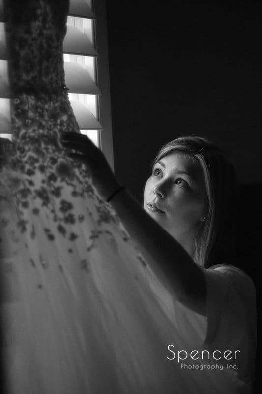 bride prepping wedding dress for ceremony at St. Hilary