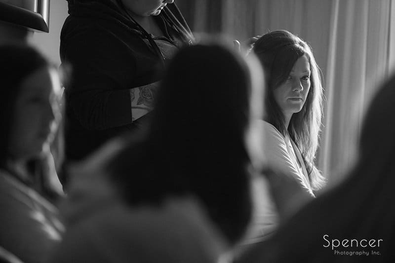  bride looking at her bridesmaids as she gets ready