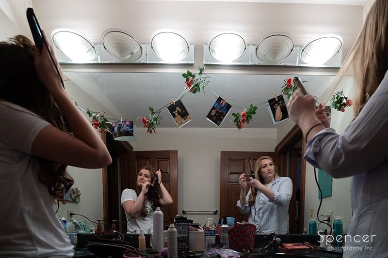 bride and maid of honor prepping for wedding day