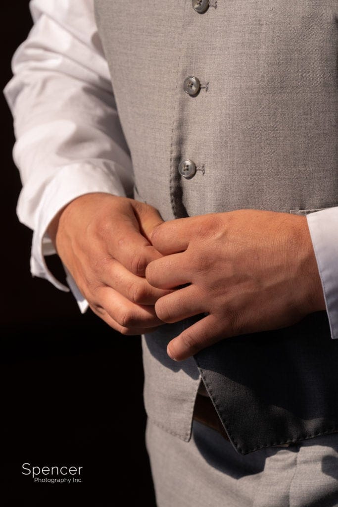 groom buttoning his jacket