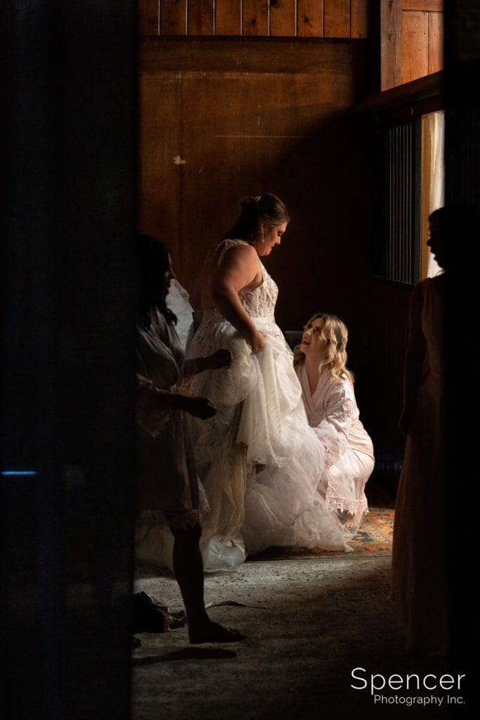 bride putting on wedding dress at Parker Barn
