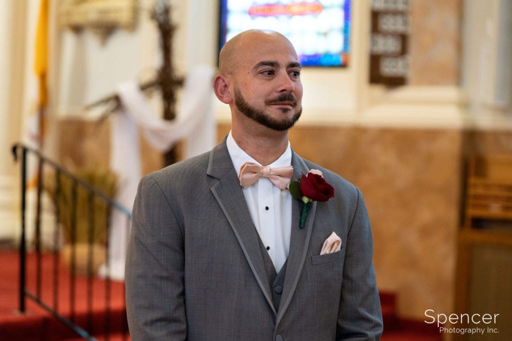 groom watching bride walk down aisle